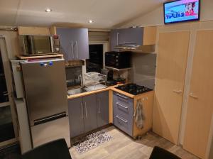 eine kleine Küche mit Kühlschrank und Mikrowelle in der Unterkunft Camping La Marine in Le Grau-du-Roi + 8 Fotos