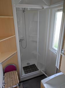 eine Dusche mit Glastür im Badezimmer in der Unterkunft Camping La Marine in Le Grau-du-Roi