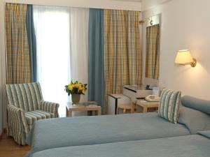 a hotel room with a bed and a chair at The Park Hotel Piraeus in Piraeus