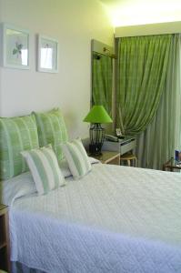 a bedroom with a large bed with green curtains at The Park Hotel Piraeus in Piraeus