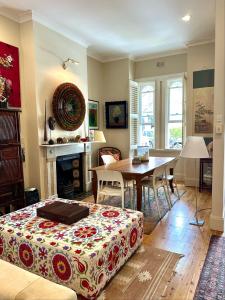 a living room with a bed and a dining room table at Art-Filled Designer Terrace in Chic Woollahra in Sydney
