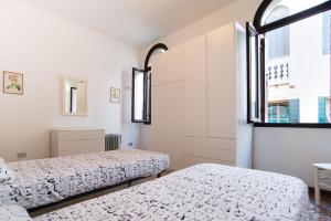 two beds in a room with two windows at Lustraferi Apartment in Venice