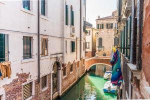 un canal entre dos edificios con un puente en Lustraferi Apartment, en Venecia