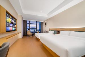 Postel nebo postele na pokoji v ubytování Tonglu City Center Rosery Hotel