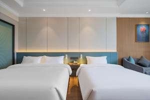Postel nebo postele na pokoji v ubytování Tonglu City Center Rosery Hotel