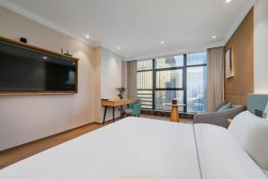 Postel nebo postele na pokoji v ubytování Tonglu City Center Rosery Hotel