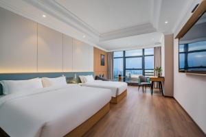 Postel nebo postele na pokoji v ubytování Tonglu City Center Rosery Hotel