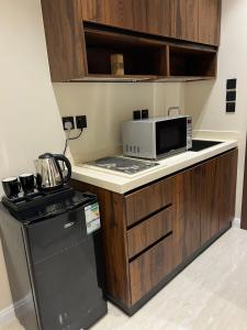 a small kitchen with a microwave and a stove at استديو أنيق كلاسيكي in Riyadh