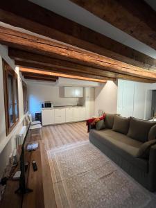 Una sala de estar con un sofá y una cocina. en Venexiana Suite, en Venecia