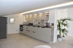 a white kitchen with a counter with a sink at I Secolari di Giulia in Avola