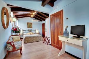 Schlafzimmer mit einem Bett und einem Schreibtisch mit einem TV in der Unterkunft Locanda Antico Fiore in Venedig