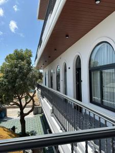 a balcony of a building with a tree at Homestay Mr Hồng Vĩnh Hy in Ninh Hải