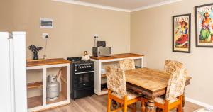a kitchen with a table and a stove and a microwave at Amberdale Estate Budget Self Catering in Queenstown