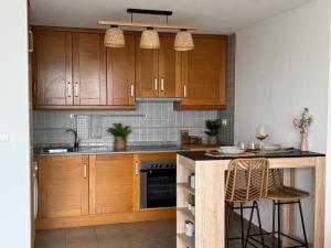 a kitchen with wooden cabinets and a counter top at El Olivo in Benimantell