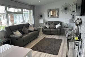 ein Wohnzimmer mit Sofa und Tisch in der Unterkunft Dog friendly chalet in Hemsby by Winterton Cottages in Hemsby