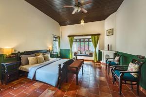a bedroom with a bed and a ceiling fan at SaffronStays Calamondinn Bungalow, Coorg in Gonikoppal