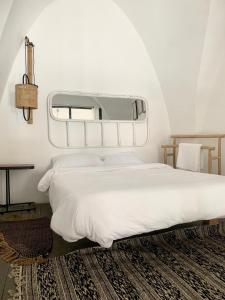 een slaapkamer met een groot wit bed en een spiegel bij The Temple Jaffa in Tel Aviv