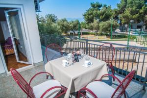 a white table with red chairs on a balcony at Apartment Vesna in Podaca