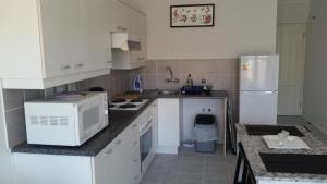 a kitchen with white cabinets and a white refrigerator at Bradclin at Mutual, Pinelands in Pinelands