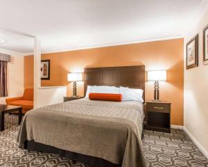 Una habitación de hotel con una cama y dos lámparas. en Rodeway Inn & Suites Colton-Riverside, en Colton