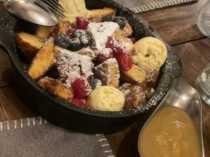 a skillet filled with fruit and sugar on a table at Hotel Domizil in Ingolstadt