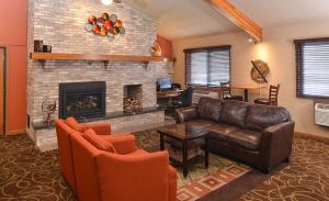 a living room with a couch and a fireplace at AmericInn by Wyndham Fergus Falls Conference Center in Fergus Falls