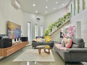 a living room with two couches and a tv at Mount Austin Landed Homestay 16pax Karaoke Jacuzzi BBQ by Stayrene in Johor Bahru