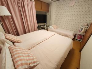 神戸市にあるTakaraboshi room 301 Sannomiya 10 minのベッド2台とテーブルが備わった病室
