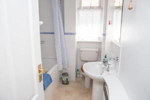 a bathroom with a sink and a toilet and a window at Sherriffs, Bantham overlooking the estuary and Burgh Island in Bigbury on Sea
