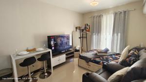 ein Wohnzimmer mit Sofa und Flachbildfernseher in der Unterkunft Be Housed Studio in Lapu Lapu City