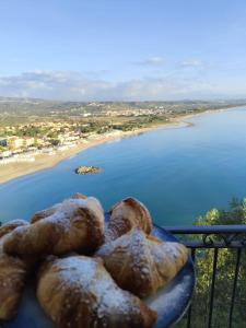 a group of breads on a balcony overlooking a beach at Luna Convento Copanello B&B in Stalettì
