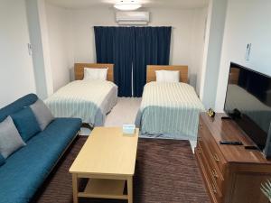 a living room with two beds and a couch at Feliz Kumamoto in Kumamoto