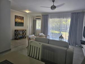 a living room with a couch and a large window at Sea's the Day in St Lucia