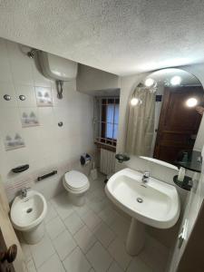 a bathroom with a sink and a toilet and a mirror at Casa dell Erbe in San Gimignano
