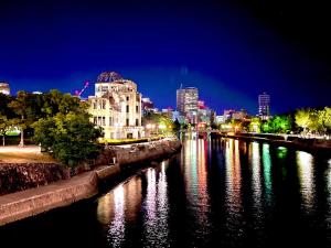 a view of a river with a city at night at 広島Riverside house第2ひまわり301号室 in Hiroshima