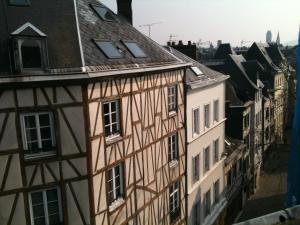 un viejo edificio con sus sombras a su lado en Hotel Dandy Rouen centre en Rouen