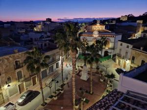 a city street with palm trees and a building at El Palacete de Cuevas in Cuevas del Almanzora