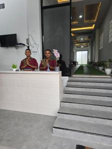 two men standing at a counter in a building at Achazia Homestay in Labuan Bajo