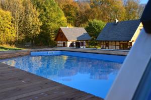 a swimming pool with a house in the background at Lawendowa Osada in Przywidz