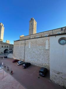 a group of cars parked in a parking lot next to a building at Casa dell Erbe in San Gimignano