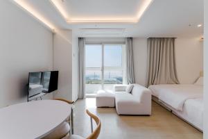 a bedroom with a bed and a tv and a couch at Marant Residence Hotel Busan Station in Busan