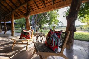 two chairs with colorful pillows sitting on a porch at Senalala Safari Lodge in Klaserie Private Nature Reserve