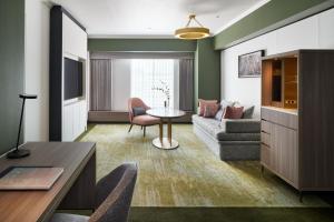 a living room with a couch and a table at RIHGA Royal Hotel Osaka, Vignette Collection by IHG in Osaka