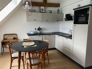 kuchnia ze stołem, krzesłami i lodówką w obiekcie Studio charmant à Sauzon avec WiFi et vue port - FR-1-418-185 w mieście Sauzon