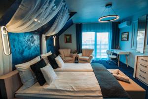 a bedroom with a large bed with blue walls at Ilmar House in Cluj-Napoca