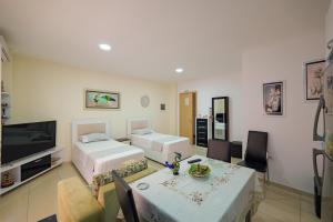 a living room with two beds and a dining room at Vila Kristiano Ksamil in Ksamil
