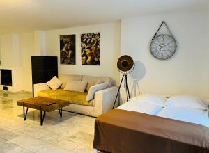 a bedroom with a bed and a couch and a clock at Old Town View in Cologne