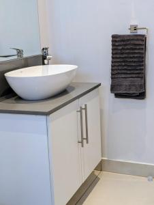 a bathroom with a white bowl sink on a counter at Mopani Villa Victoria Falls in Victoria Falls +72 photos