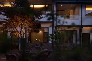 丽江One Zen Lodge Snowy Haven的一座在晚上有椅子的建筑