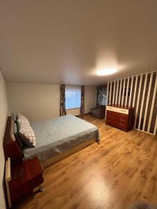 a bedroom with a bed and a wooden floor at Svečių namelis in Kaunas